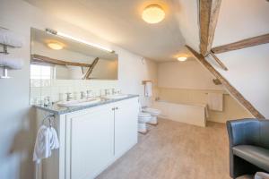 a bathroom with two sinks and a toilet and a mirror at The Merchant House, Ipswich in Ipswich