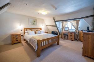 a bedroom with a bed and a desk and a window at The Merchant House, Ipswich in Ipswich
