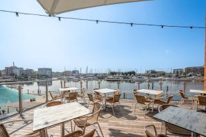 a patio with tables and chairs overlooking a marina at The Merchant House, Ipswich in Ipswich