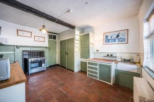 a kitchen with green cabinets and a tile floor at The Merchant House, Ipswich in Ipswich +24 photos