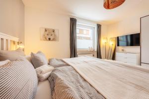 a bedroom with two beds and a television in it at Halali Braunlage in Braunlage