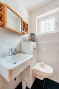 a white bathroom with a sink and a toilet at Halali Braunlage in Braunlage +14 photos