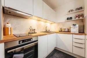 a kitchen with white cabinets and a stove at Halali Braunlage in Braunlage