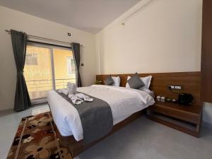 a bedroom with a bed with a stuffed animal on it at Shreya Bungalow Mahabaleshwar in Mahabaleshwar