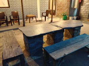 a wooden bench and a wooden table and chairs at Ekatma Stays - Farm & Homestay, Kakrighat in Shitlakhet