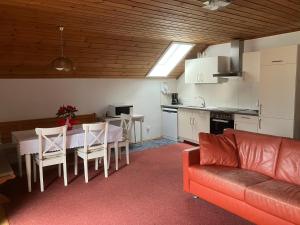 a kitchen and a living room with a table and a couch at Ferienwohnung und Zimmer Kassar Bikertipp in Mauterndorf