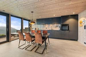 a dining room with a table and chairs in a kitchen at Authentic Cabin Life With Løefjell View in Rysstad
