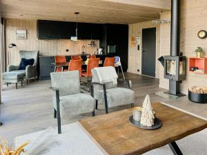 a living room with chairs and a table with a fireplace at Authentic Cabin Life With Løefjell View in Rysstad