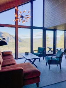 a living room with a couch and chairs and a large window at Authentic Cabin Life With Løefjell View in Rysstad +32 photos