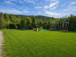 a large grassy field with playground equipment on it at Portki - Cztery Pory Roku in Pszczeliny +6 photos