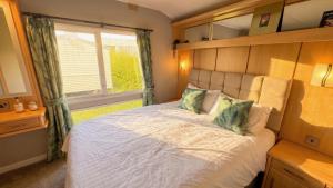a bedroom with a large bed and a window at Bag End, Near Porth Beach, Garden & Stream in Newquay Bay Resort +13 photos