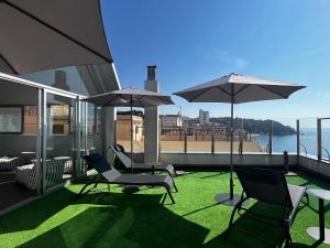 a patio with chairs and umbrellas on a building at Hotel Excelsior in Lloret de Mar