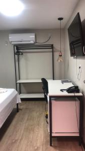 a room with a bed and a desk with a projector at Aiezza Hotel in Barcarena
