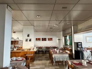 a dining room with tables and chairs in a restaurant at Hotel Cristallo in Udine