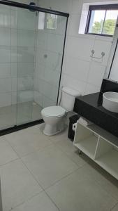 a bathroom with a toilet and a shower and a sink at Aiezza Hotel in Barcarena