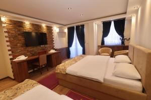 a bedroom with two beds and a desk and a television at Agušević Home in Novi Pazar