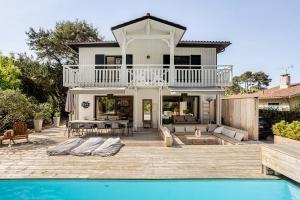 a house with a swimming pool in front of a house at Villa Lilas Cap-Ferret in Lège-Cap-Ferret