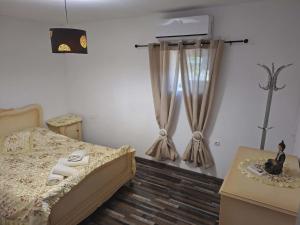 a bedroom with a bed and a window with curtains at Simbas House in Leonidio