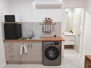 a kitchen with a washing machine and a sink at Executive Studio - Private Parking in Holmview