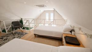 a bedroom with a bed and a chair in a room at Holzhaus Sikonda in Komló