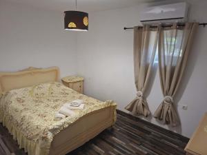 a bedroom with a bed and a window with curtains at Simbas House in Leonidio