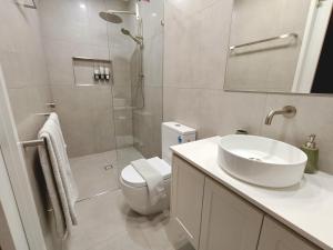 a bathroom with a toilet and a sink and a shower at Executive Studio - Private Parking in Holmview