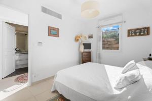 a white bedroom with a bed and a window at Grand T2 proche plage in Six-Fours-les-Plages
