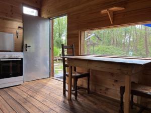 a kitchen with a table and a large window in a cabin at La Cabane du Bûcheron in La Teste-de-Buch