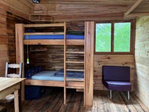 a bedroom with bunk beds in a wooden cabin at La Cabane du Bûcheron in La Teste-de-Buch
