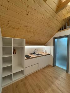 a kitchen with white cabinets and a wooden ceiling at Chalet La Martina in Zuberec