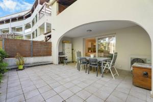 a patio with a table and chairs and a building at Grand T2 proche plage in Six-Fours-les-Plages