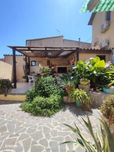 a patio with a bunch of plants and a building at Mambo House in Sarroch