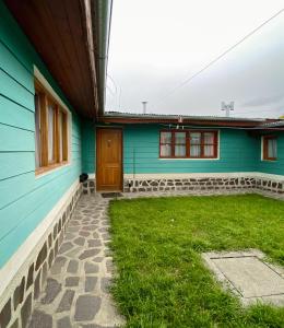a blue house with a yard in front of it at Departamento Quetro in Trevelín