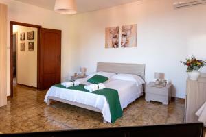 a bedroom with a large white bed with a green blanket at Taormina Matthome in Taormina