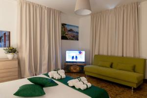 a living room with a green couch and a bed at Taormina Matthome in Taormina +29 photos