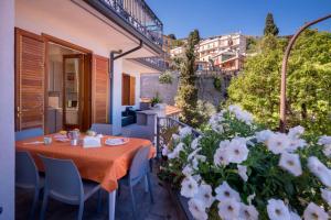 a table and chairs on a balcony with white flowers at Taormina Matthome in Taormina