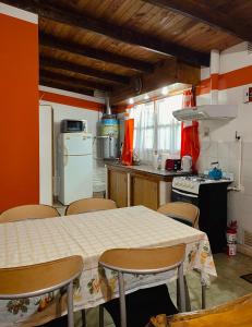 a kitchen with a table and chairs and a kitchen with a refrigerator at Departamento Quetro in Trevelín
