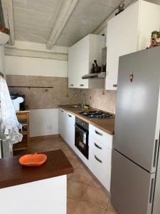 a kitchen with white cabinets and a refrigerator at Casotta Luca in Vigevano