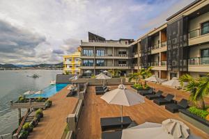 a hotel with a deck with chairs and umbrellas at Two Seasons Coron Bayside Hotel in Coron