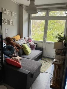 a room with a couch with stuffed animals on it at Bazylika hostel in Warsaw