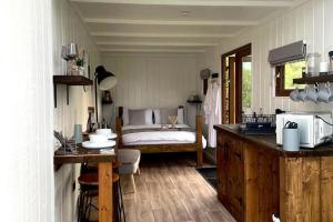 a bedroom with a bed in the corner of a room at Trethowels Grey Hidden hut in St Austell