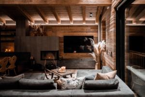 a living room with a couch and a fireplace at Kellnergut chalet Frieda in Mühlbach am Hochkönig