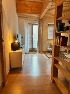 a living room with a desk with a tv and a book shelf at Apartment Auszeit im Ski- und Wandergebiet Spitzingsee - neu renoviert in Schliersee