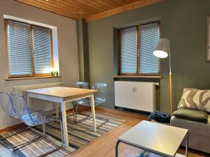 a living room with a table and chairs and a couch at Apartment Auszeit im Ski- und Wandergebiet Spitzingsee - neu renoviert in Schliersee