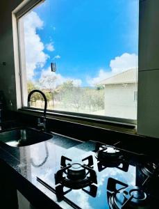 a kitchen counter with a sink and a window at Serra do Cipó Casa Baru in Santana do Riacho