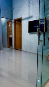 an empty room with a glass door and a television at Serra do Cipó Casa Baru in Santana do Riacho