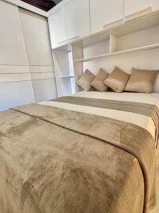 a bedroom with a large bed with white cabinets at Serra do Cipó Casa Baru in Santana do Riacho
