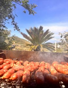 a bunch of hot dogs and sausages cooking on a grill at Dimora dei Cardinali in Agropoli