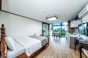 una camera con letto e lavandino e una cucina di Olleyo Resort a Seogwipo