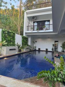 a swimming pool in front of a house at Infinity Bay Suites in Puerto Galera +24 photos